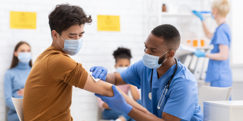 photo of healthcare worker preparing a patient to receive a vaccine in a sunny room