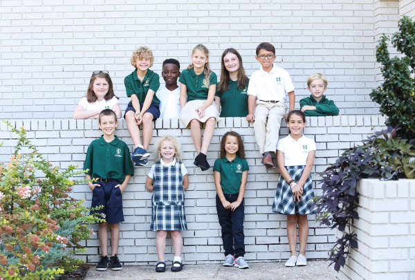 photo of tallahassee classical students sitting in front of a white brick wall