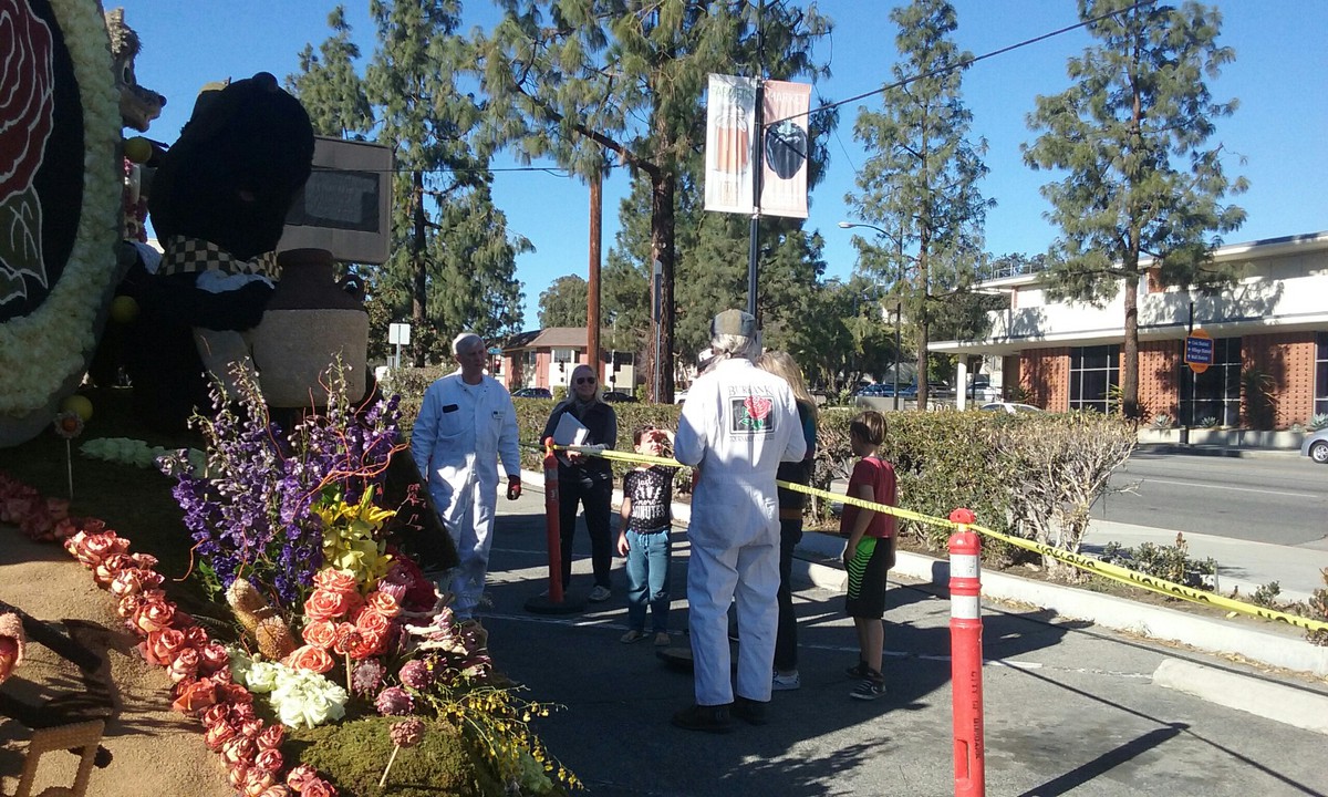 Burbank Rose Bowl volunteers standing outside next to a float blocked off by caution tape