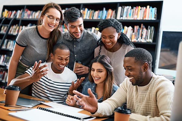 group of college students smiling in library