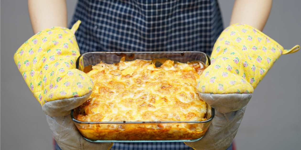 photo of person holding a cheesy casserole dish